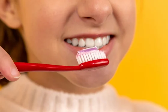 Woman smiling while brushing her teeth