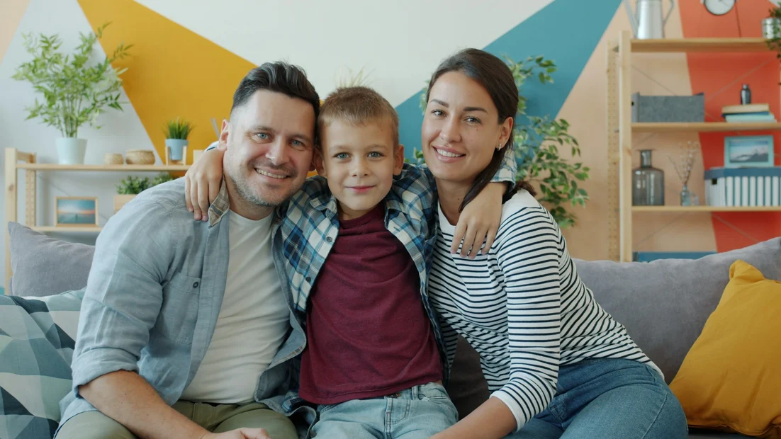 A smiling family of three at home
